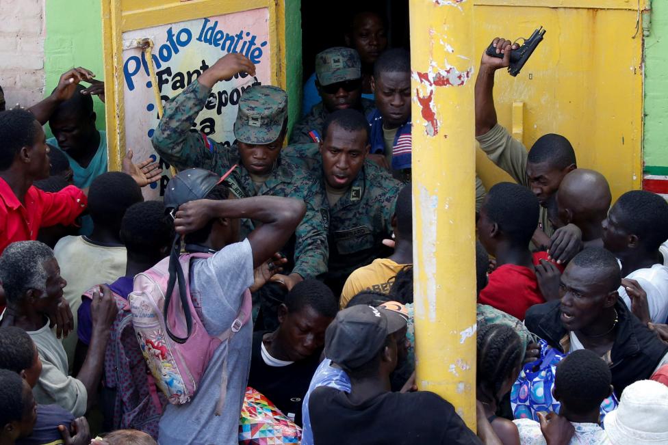 Солдаты стреляют в воздух в попытке навести порядок в толпе людей, которые ждут раздачи гуманитарной помощи в пострадавшем от урагана «Мэтью» городе Жереми на Гаити.