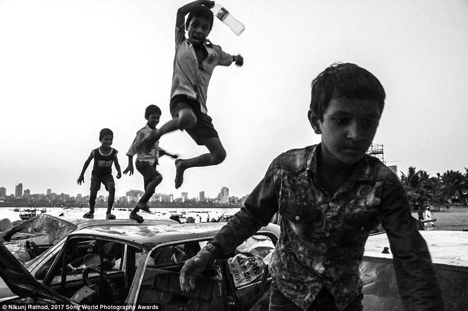 Дети играют на свалке автомобилей в Мумбаи, Индия.