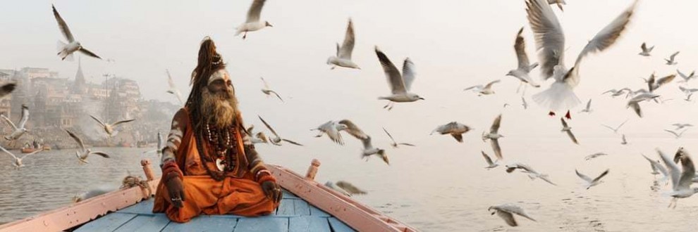 Садху (святой человек) на лодке в Варанаси, Индия. Фотография: Джейсон Деннинг.